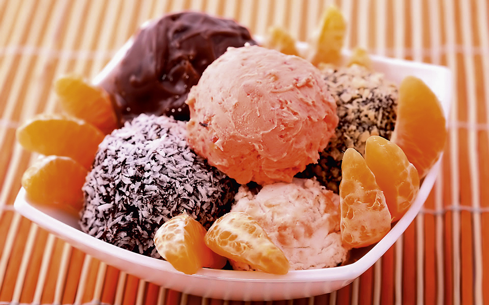 Mixed ice cream scoops with orange slices